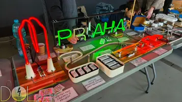 Pohled na jeden ze stolů s vystavovanými neony a výrobky